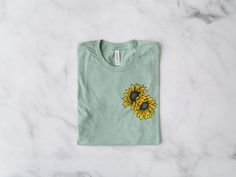 Sunflower T-Shirt *Product Details - Unisex T-Shirt - Ultra soft Bella Canvas 3001 - Designed with high quality pre-shrunk combed and ring-spun cotton - Features a crew neck with shoulder to shoulder taping and side seams *Sizing and Colors - Please refer to sizing and color charts in the images *Fabrication - Solid colors: 100% combed and ring-spun cotton - Heather colors: 52% combed and ring-spun cotton, 48% polyester - Athletic Heather colors: 90% combed and ring-spun cotton, 10% polyester - Cotton Crew Neck T-shirt With Sunflower Design, Relaxed Fit Short Sleeve T-shirt With Sunflower Design, Cotton T-shirt With Sunflower Design, Relaxed Fit Cotton T-shirt With Sunflower Design, Crew Neck Cotton T-shirt With Sunflower Design, Spring Green T-shirt With Custom Print, Casual Sunflower Design T-shirt With Relaxed Fit, Casual Sunflower Design T-shirt In Relaxed Fit, Casual Sunflower Design Crew Neck T-shirt