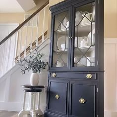 a blue china cabinet sitting next to a stair case