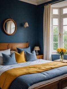 a bedroom with blue walls and yellow pillows on the bed, along with two windows