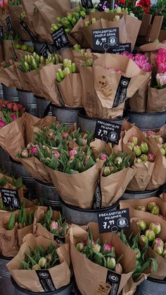 many different types of flowers in brown paper bags with price tags on each one side