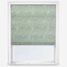 a green roman blind with an abstract design on the top and bottom, in front of a white window