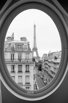 the eiffel tower is seen through a round window in black and white photo