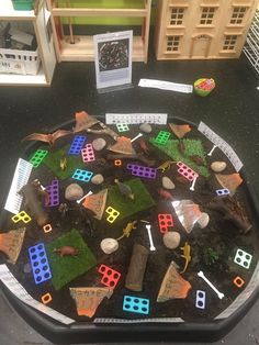 a table topped with lots of different types of toy buildings and toys on top of it