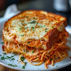 a close up of a plate of food with spaghetti and cheese on it's side