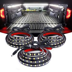 the back end of a pickup truck with its lights on and cables attached to it