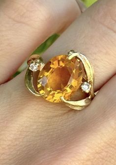 This is a vintage retro era ring made of 10k yellow gold. This ring features a citrine stone as the main stone, with two diamonds as secondary stones. The ring is designed with a retro theme and has a yellow color. The ring size is 5.75. Weights 3.3g 11.4mm x 9.1mm citrine Retro Era, Retro Theme, Diamonds Ring, Citrine Stone, Retro Stil, Vintage Ring, Rings Statement, Yellow Color, Diamond Rings