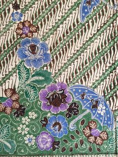 a close up view of a tie with flowers and leaves on the bottom half of it