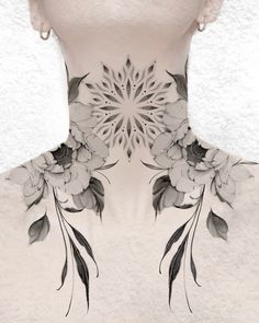 the back of a woman's neck with flowers and leaves painted on her chest