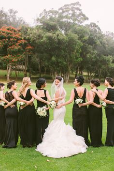 a group of women standing next to each other on top of a lush green field