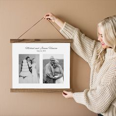 a woman holding up a framed photo with two pictures hanging on it's side