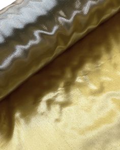 two different shades of gold and silver fabric on top of each other in close up