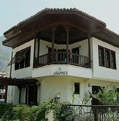 a large white building with wooden balconies on the top and second story balcony