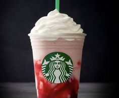 a red drink with whipped cream and a green straw