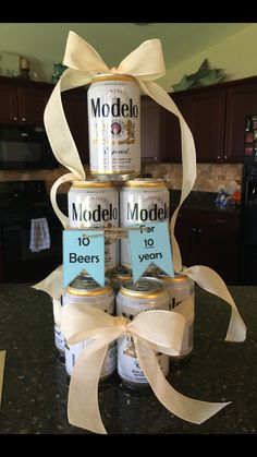 three cans of modelo beer stacked on top of each other with ribbons around them