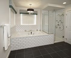 a bathroom with black and white tile on the floor, tub, shower stall and sink