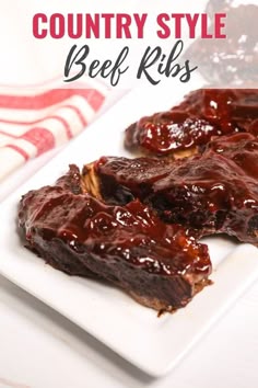 two pieces of beef ribs covered in bbq sauce on a white plate with the title country style beef ribs