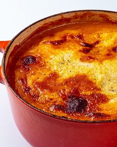 a red pot filled with food on top of a white table