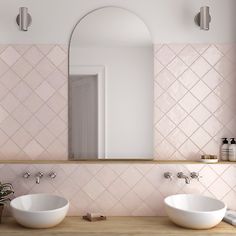 there are two sinks in this bathroom with pink tiles on the wall and mirror above them