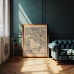 a framed map is sitting on the floor next to a couch in a room with green walls