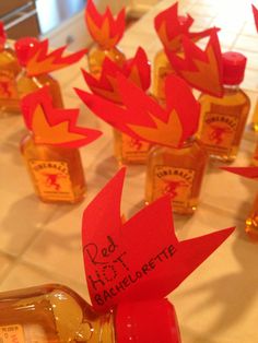 bottles with red paper birds on them sitting on a table next to orange and yellow decorations