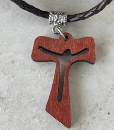 The necklace with the Franciscan Cross is a symbol of the dignity of the children of God, because it is the Cross that has sustained Christ. The Tau "T" is the last letter of the Hebrew alphabet. ... The meaning given to the Tau Cross is similar to that of the Latin Cross. It represents Christian devotion, a sign of penance, redemption and protection from God and redemption in Christ. It is a perfect gift for every Christian PRODUCT DETAILS: This leather necklace measures 20 inches long, or you can choose the size you need, the wooden cross measures 1.7 inches, if you want another size I will gladly do it, please send me a message with the measurement you need, it will be an honor work for you!! All our pieces are completely handmade so there may be a small difference between them, no two Brown Cross Pendant Necklace For Gift, Brown Cross Pendant Necklace As Gift, Father's Day Gift Cross Necklace, Brown Crucifix Jewelry For Gifts, Brown Crucifix Jewelry Gift, Brown Jewelry Gift For Father's Day, Crucifix Necklace For Father's Day Gift, Father's Day Gift Crucifix Necklace, Spiritual Cross Jewelry For Father's Day