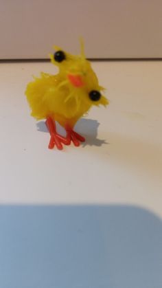 a yellow toy duck sitting on top of a white table