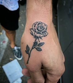 a hand with a rose tattoo on it