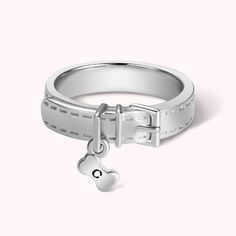 a white gold ring with a heart charm and a lock on the side, in front of a white background