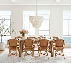 a dining room table with chairs and a chandelier hanging from it's ceiling