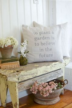 a bench with flowers and a pillow on it