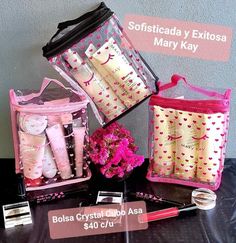 three bags with pink and white designs on them, one is filled with personal care products