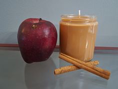 an apple and cinnamon stick next to a candle