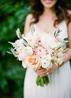 a woman holding a bouquet of flowers in her hands