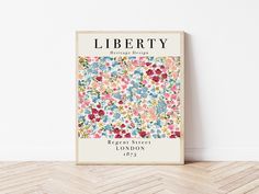 the liberty book is on display in front of a white wall and wood flooring