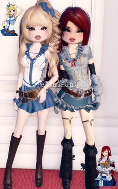 two dolls standing next to each other in front of a white wall and red carpet