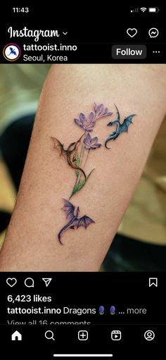 an image of a tattoo on the arm with flowers and dragon in purple inks