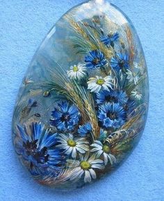 a glass vase filled with blue and white flowers on top of a blue table cloth