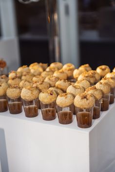 cupcakes and muffins are arranged in rows on a white tablecloth