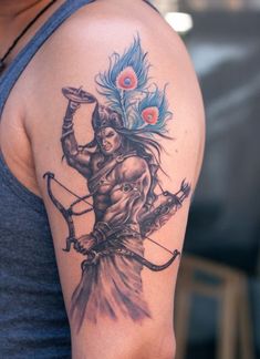 a man with a tattoo on his arm holding a bow and arrow