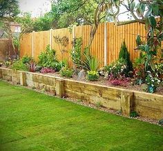 a garden area with wooden fence and green grass