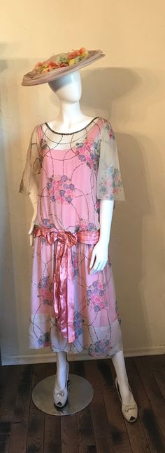 "Here is a beautiful 1920's Floral silk chiffon dress. Such a pretty one in shades of pink. The silk chiffon is an off white color with the floral, print in shades of pinks, blue and yellow. It has the gorgeous bugle beading with the cape like over sleeves, drop waist and pink satin belt with bow. The under slip dress is attached and is a bright pink silk sateen with drawstring at bust. There are side snaps in the chiffon, under slip has no openings. It is in good condition for this age and type Summer Vintage Flapper Dress For Vintage Events, Vintage Summer Evening Flapper Dress, Summer Art Deco Dress For Vintage Events, Art Deco Summer Dresses For Vintage Events, 1920s Style Dresses For Vintage Summer Events, 1920s Style Summer Dresses For Vintage Events, 1920s Summer Evening Dresses, 1920s Style Flapper Dress For Spring Party, Vintage Pink Chiffon Dress