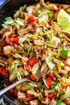 a skillet filled with cabbage, meat and vegetables