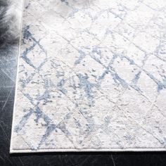 a white rug with blue and gray designs on it