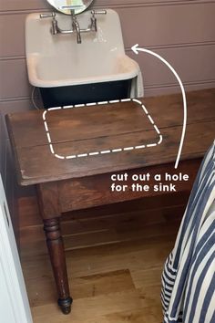 a bathroom sink sitting under a mirror next to a wooden table with an arrow drawn on it