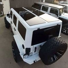 the white truck is parked next to other vehicles in a garage with no doors on it