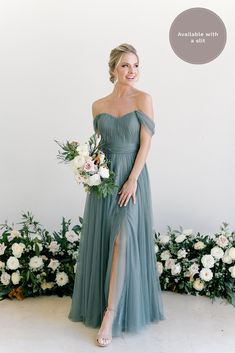 a woman standing in front of flowers wearing a green dress with thigh high slits