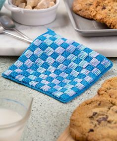 cookies and milk are sitting on the counter next to baking utensils, including an oven mitt