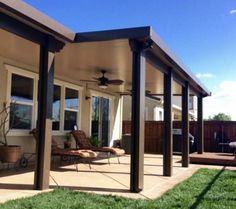 a covered patio area with chairs and an outdoor ceiling fan in the middle of it