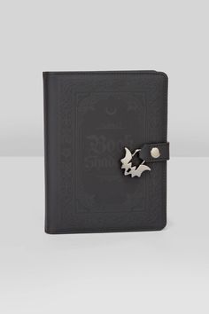 a black book with a metal bird on the front and two silver birds on the back