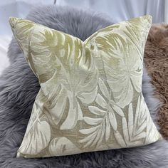 a close up of a pillow on a furnishing area with a white curtain in the background